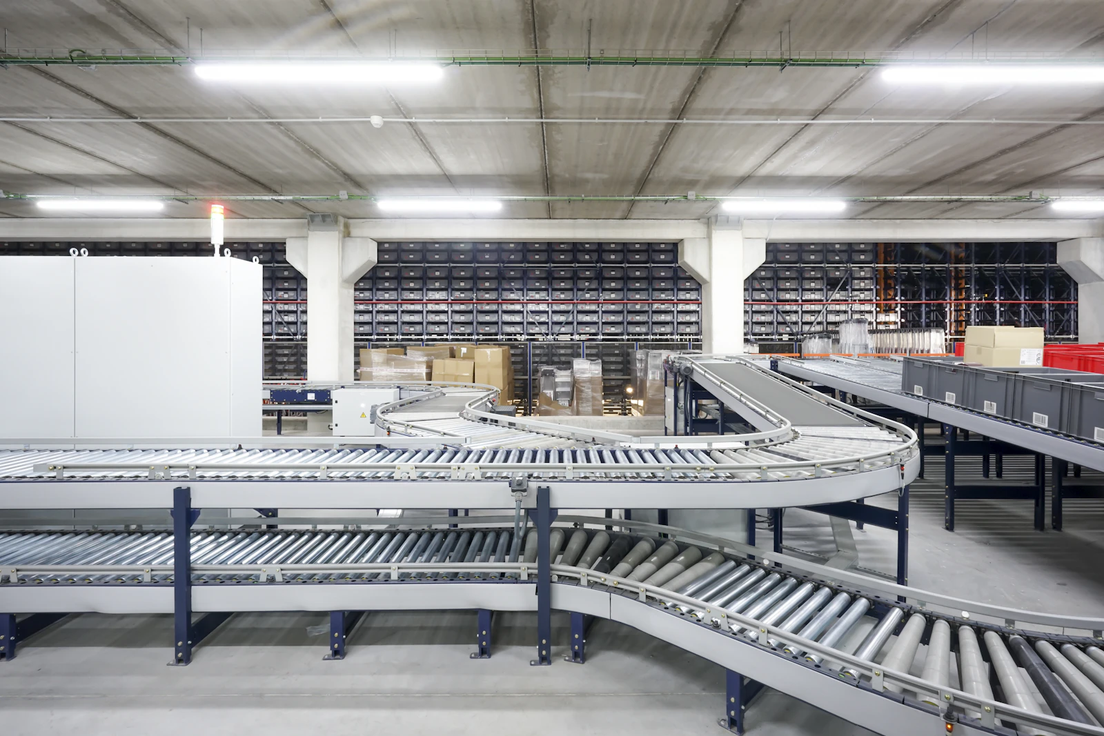 Curved roller conveyors and storage bins in a warehouse.