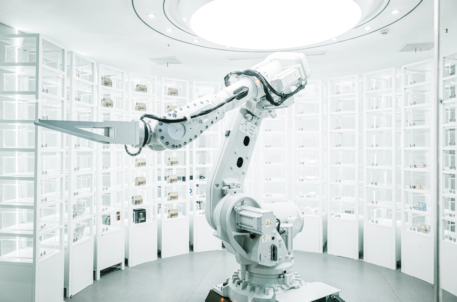 A white industrial robot arm in front of display shelves.